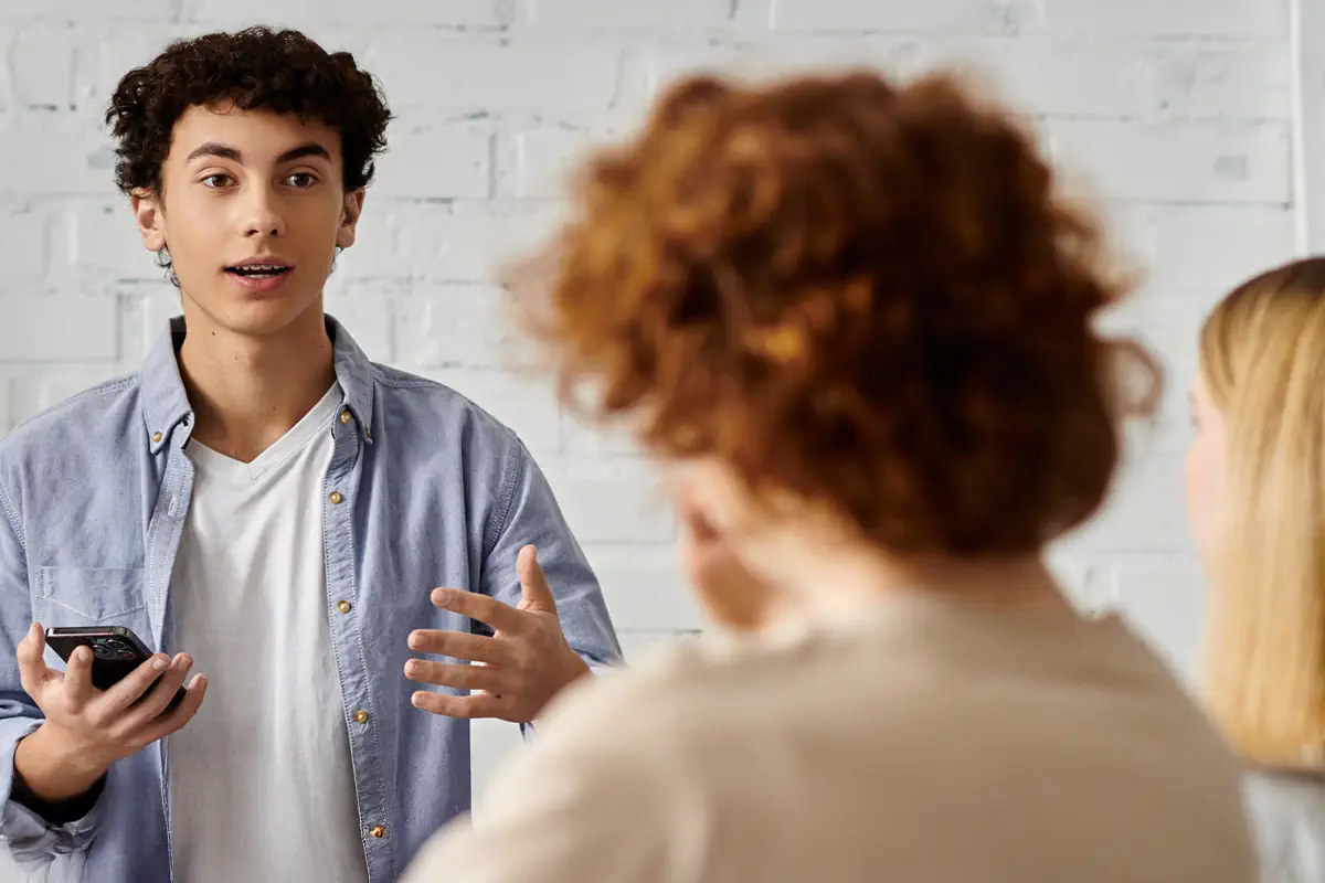 teenage boy talking to two other people